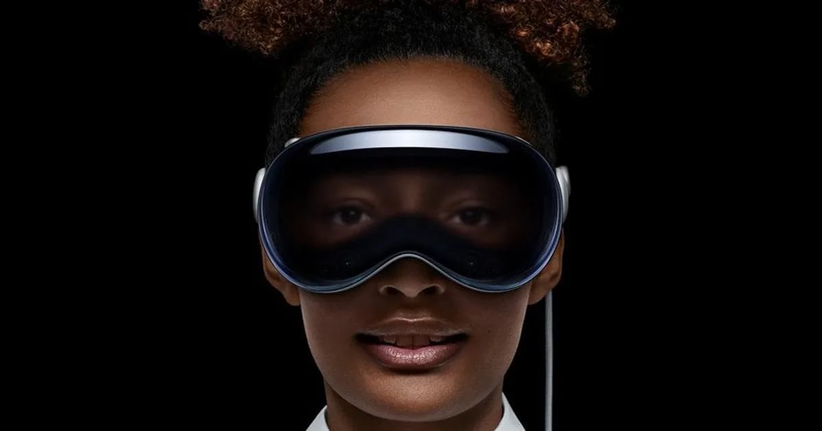A woman wearing a spatial computing headset against a dark background