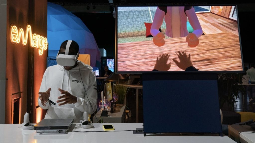 A learner using a VR headset while the virtual scene is shown on a nearby screen
